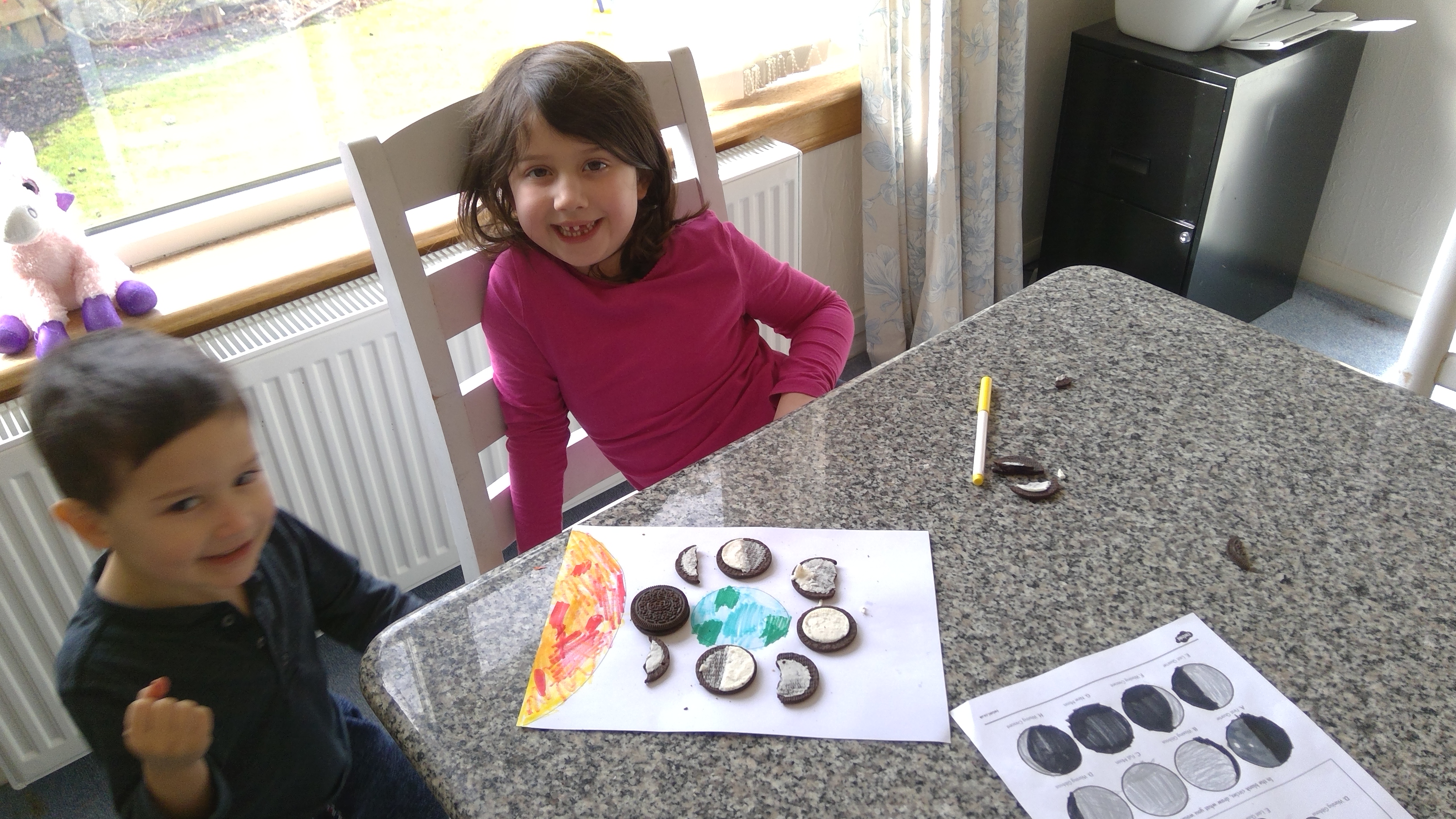 Madison and her brother using oreo biscuits to show the phases of the moon